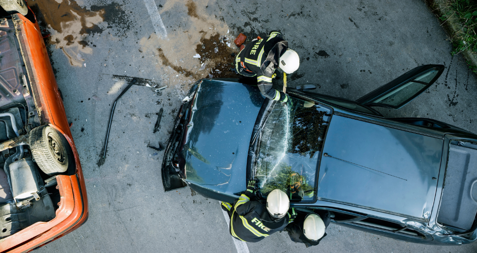 strażacy gaszą samochód z wypadku